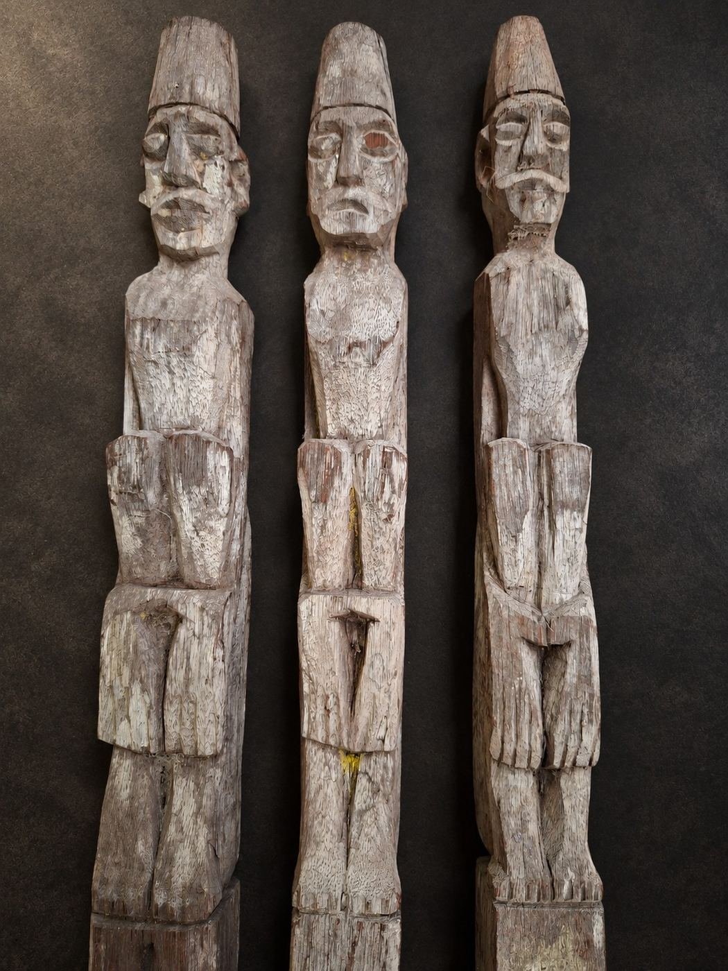 The Lamin Assembly — Set of Three, weathered carved wood with surviving pigment traces; custom powder-coated iron mounts, shown complete